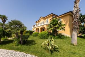 una casa amarilla con palmeras delante en Villa Frida - Piscina privata ed Eventi a Lecce, en San Pietro in Lama