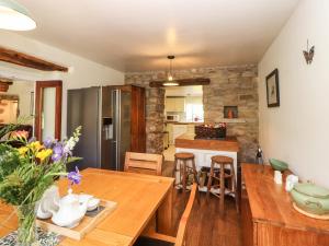 a kitchen and dining room with a wooden table and chairs at Roger Pot in Sedbergh