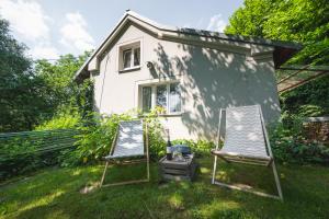two chairs and a grill in front of a house at Chaloupka pod skalou in Libošovice
