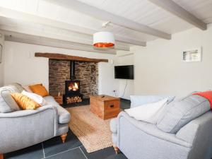 a living room with two couches and a fireplace at Greenbank in Perranporth