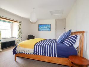 a bedroom with a bed with blue and yellow sheets at Greenbank in Perranporth