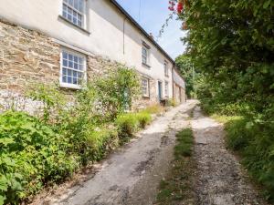 an old dirt road in front of a stone building at Greenbank in Perranporth