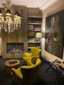uma sala de estar com cadeiras amarelas e uma lareira em 't Hartje van Brugge em Bruges
