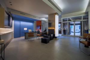 a living room with a blue wall and a table and chairs at Hotel Velino in Avezzano