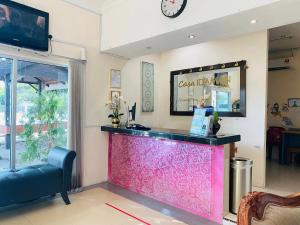 a bar in a restaurant with a clock on the wall at Casa Idaman Motel in Pantai Cenang