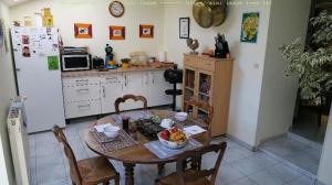 una cocina con una mesa con un bol de fruta. en Chez Hervé, en Saint-Mars-sur-Colmont