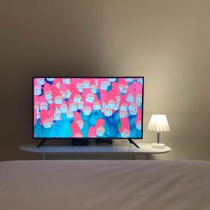 a flat screen tv sitting on a table with a lamp at Hostel Espace in Chuncheon