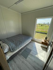 een kleine slaapkamer met een bed en een raam bij Domki letniskowe Bali in Jezierzany