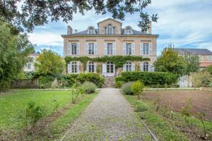 una vieja mansión con un camino delante de ella en La Maison de maître, en Fontenay-le-Comte