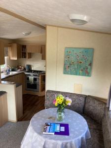 a living room with a couch and a table with flowers at Park Gate, Colyton, farm,near beaches-‘Annie’ in Colyton