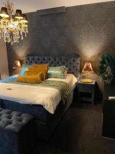 a bedroom with a bed with a blue headboard and two lamps at 't Hartje van Brugge in Bruges