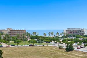 a view of a parking lot with palm trees and the ocean at Hauzify I Loft Ancora in La Pineda