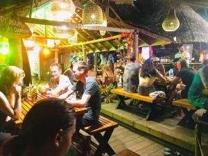 a group of people sitting at tables in a bar at Backpack Beach Hostel & Reggae Bar in Galle