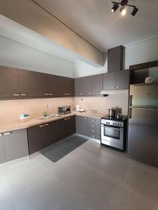 a large kitchen with a stove and a refrigerator at House Of Diamond in Kírra