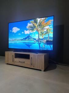 a flat screen tv sitting on a wooden entertainment center at House Of Diamond in Kírra