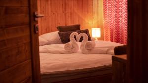 1 dormitorio con 2 toallas en forma de cisne en una cama en Vila Somani, en Nová Lesná