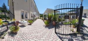 a brick walkway with potted plants and a fence at Hotel Porta Rivera in LʼAquila