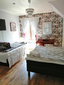 a bedroom with two beds and a piano at Guesthouse Lokinlaulu in Kotka