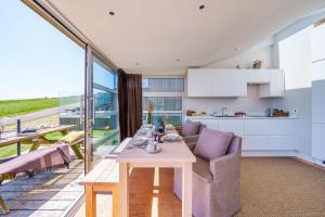 a kitchen and living room with a table and a couch at The Billy Shed in Bridport