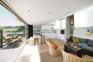 a living room and kitchen with a couch and chairs at The Billy Shed in Bridport