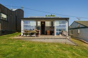 a house with a deck with a table on it at The Billy Shed in Bridport +17 photos