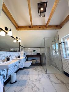 uma casa de banho com 2 lavatórios e um chuveiro em Abrahams Bayr Cottage em Schechen
