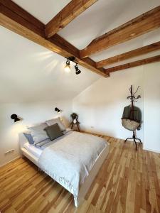 a bedroom with a large bed and wooden ceilings at Abrahams Bayr Cottage in Schechen
