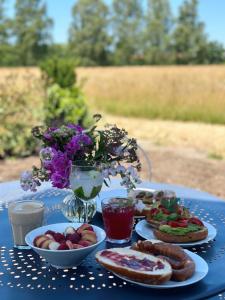 uma mesa azul com pratos de comida e flores em Abrahams Bayr Cottage em Schechen