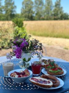 a blue table topped with plates of food and flowers at Abrahams Bayr Cottage in Schechen +59 photos
