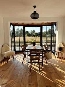 uma sala de jantar com mesa e cadeiras e uma grande janela em Abrahams Bayr Cottage em Schechen