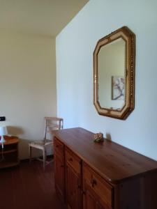 Habitación con tocador de madera y espejo en la pared. en Oasi del Garda 4, en Monzambano