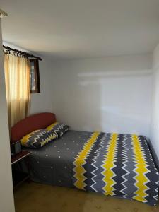 a bedroom with a bed with a yellow and blue blanket at E & V free wi fi in Podgorica