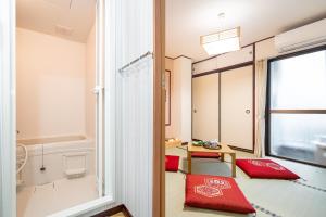 Habitación con almohada roja y ventana en NEW OPEN! Nearest JR Shinokubo and JR soubu line HIgashinakano, shinjuku 5 minute ginza 25 minute asakusa 35 minute, en Tokio 94 fotos más