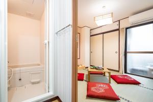 a room with a red pillow and a window at NEW OPEN! Nearest JR Shinokubo and JR soubu line HIgashinakano, shinjuku 5 minute ginza 25 minute asakusa 35 minute in Tokyo
