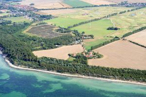 an aerial view of a farm next to the water at Hotel Ostseeland in Warnemünde
