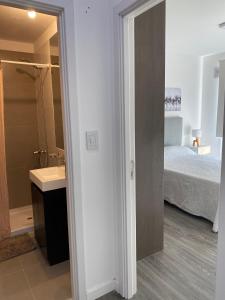 Departamentos Premium - Boero Rentals في بيلين دي إسكوبار: حمام مع سرير ومغسلة في الغرفة