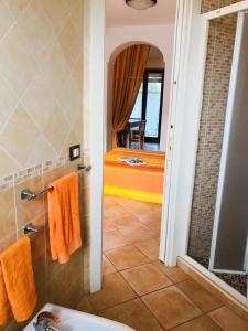 ein Bad mit einem Bett, einem Waschbecken und einem Spiegel in der Unterkunft Casa dei Nonni in Ischia