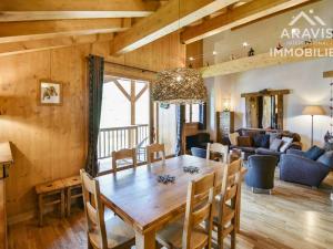 a dining room and living room with a wooden table and chairs at Appartement Le Grand-Bornand, 3 pièces, 7 personnes - FR-1-391-97 in Le Grand-Bornand