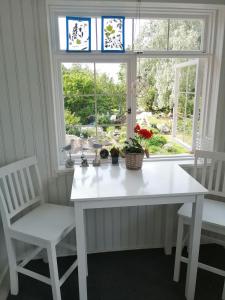 uma mesa branca e duas cadeiras em frente a uma janela em Guesthouse Lokinlaulu em Kotka