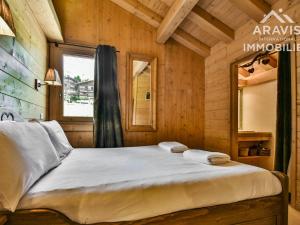 1 dormitorio con 1 cama en una cabaña de madera en Appartement Le Grand-Bornand, 3 pièces, 7 personnes - FR-1-391-97, en Le Grand-Bornand