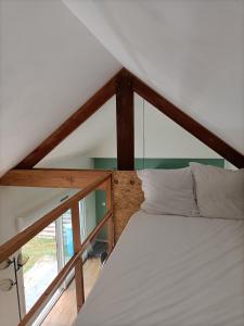 een slaapkamer met een wit bed op zolder bij La mezzanine in Pont-Aven