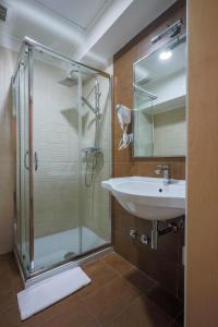 a bathroom with a glass shower and a sink at Hotel Velino in Avezzano