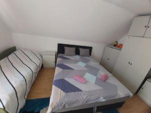 ein Schlafzimmer mit einem Bett, auf dem zwei rosa Kissen liegen in der Unterkunft Orange House in Trnovo