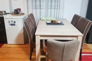 ein Esstisch mit Stühlen und ein Kühlschrank in der Unterkunft Orange House in Trnovo