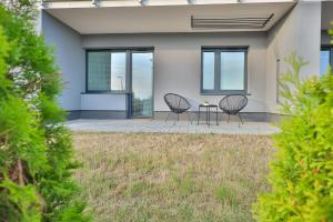 a house with two chairs and a table on a patio at Apartament Pod 6 in Uniejow
