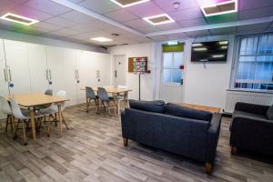 a waiting room with tables and couches and chairs at New Mansion House (Lancaster Gate) in London