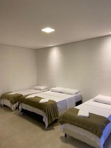 a room with three beds in a room at CHALÉS VALE DO LAGO in Capitólio