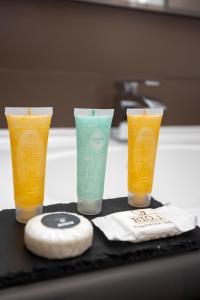 three glasses sitting on a counter with a sink at Hotel Velino in Avezzano