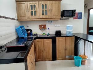 a kitchen with wooden cabinets and a counter top at #vrabode 1BHK apartment w Pool at Seacoast Retreat Varca in Talaulim