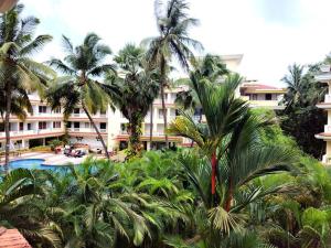 a view of a resort with palm trees and a pool at #vrabode 1BHK apartment w Pool at Seacoast Retreat Varca in Talaulim